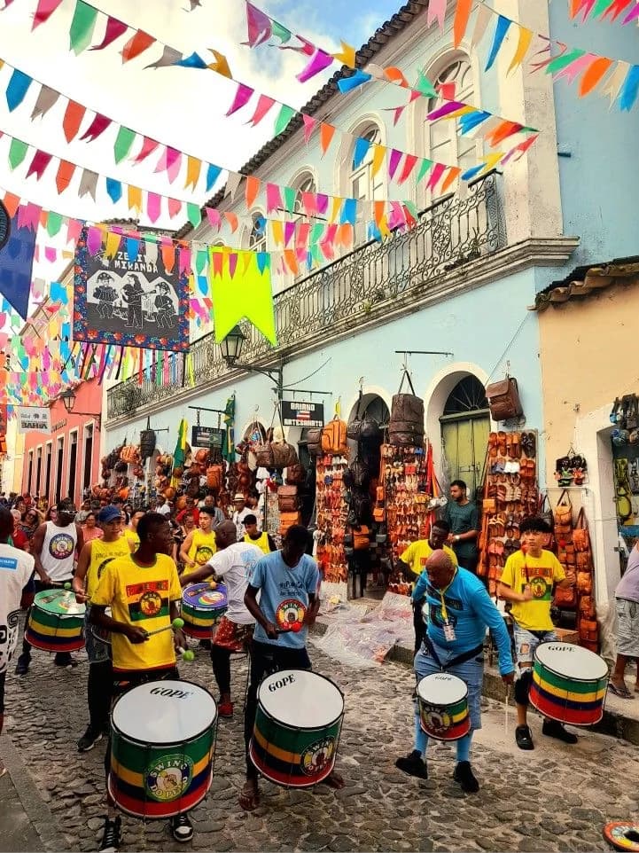 Groupe de batucada jouant du tambour dans les rues pavées du Pelourinho à Salvador de Bahia, illustrant les racines culturelles du samba.