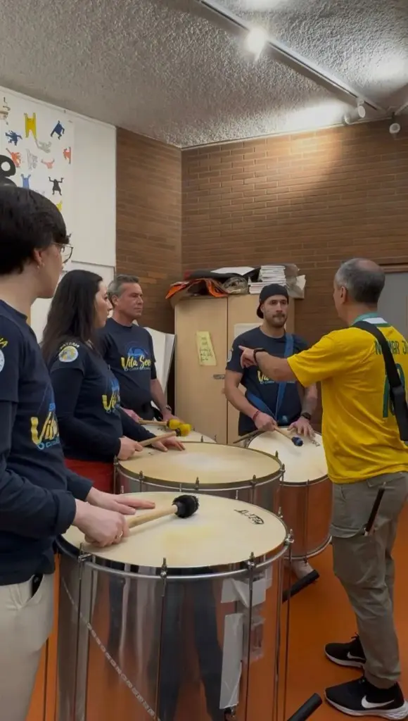 Team building batucada entreprise à Paris: cercle de participants avec surdos et mestre Pessoa Connect