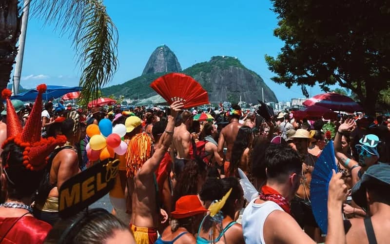 Foule en costumes de carnaval dans les rues de Rio de Janeiro, le Pain de Sucre en arrière-plan